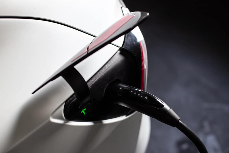 Cable de carga enchufado a la toma de un coche eléctrico