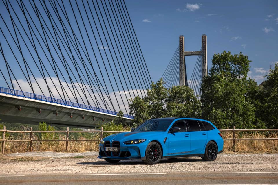 BMW M3 CS Touring azul aparcado junto a un puente atirantado; el BMW M3 es uno de los ejemplos de financiación de esta guía