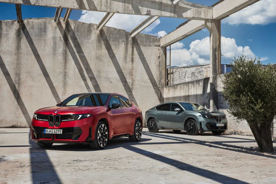 Dos BMW iX4, uno rojo y otro gris, el SUV coupé eléctrico de la Neue Klasse, en las fotos oficiales de presentación